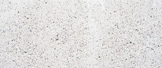 Naklejka premium Front-facing macro texture of pale concrete with recycled glass particles, subtly reflective speckled surface detail
