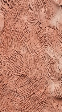 Ultra-close-up frontal view of hand-worked terracotta clay textured with delicate compressed finger grooves in organic rhythm