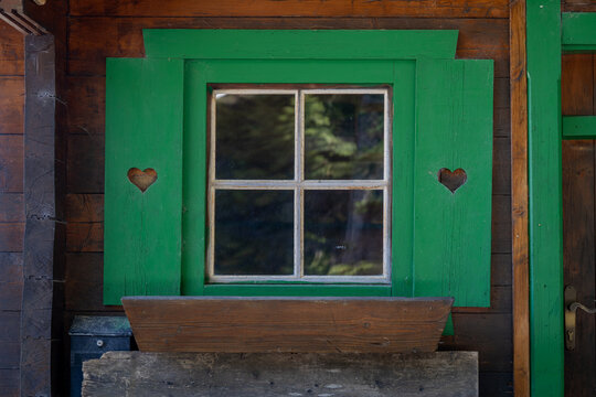 Cottage window with little hearts on the green shutters