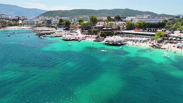Aerial view of the best beach in Ksamil, hotels and beach bars, crystal clear sea, Ionian Sea, Saranda, Albania. Drone view from above. Sea and coast with sandy beach. Summer destination on the Medite