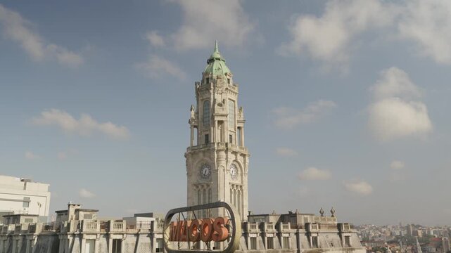 City Hall clock tower above rooftop signage and terracotta rooftops in Porto Portugal