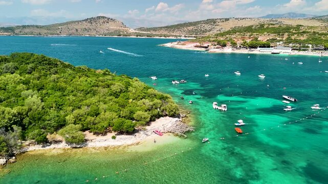 Aerial view of Ksamil beach and islands, ships near islands, crystal clear sea, Ionian Sea, Saranda, Albania. Drone view from above. Summer destination on the Mediterranean Sea, Europe
