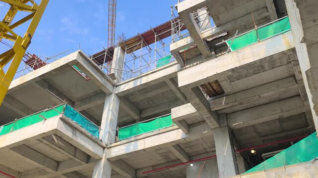 Low angle shot of a reinforced concrete cantilever beam supporting a floor slab. Structural view within an active modern building construction site.