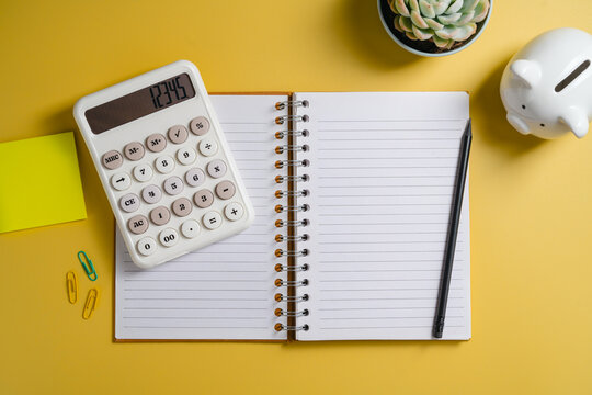 Household budgeting and savings planning with calculator, open notebook for notes and piggy bank, flat lay mockup