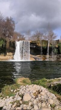 Vertical static front view of Pedrosa de la Tobalina waterfall and river pool in Burgos Spain