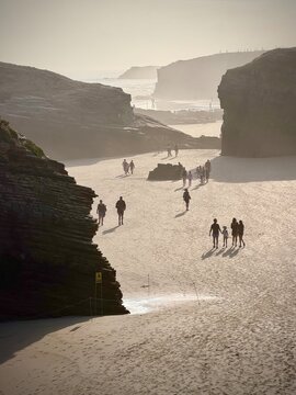 Silhouettes on the beach at low tide of playa the cathedrales, spain