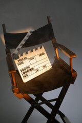 Fototapeta premium Movie director chair with clapboard slate under spotlight in film studio.