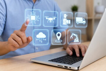 Fototapeta premium Hands interacting with digital supply chain icons over a laptop in an office