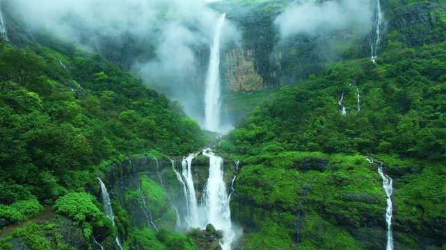 4K Aerial shot of Nanemachi waterfall flowing between lush green forest in Sahyadri range at Maharashtra, India. Scenic waterfall background. Nature landscape. Travel India.
