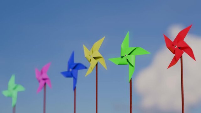 Colorful pinwheels spinning in the wind against a bright blue sky with clouds
