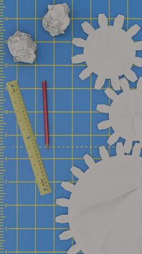Crafting process with paper gears, ruler, and pencil on a cutting mat