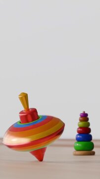 Colorful spinning tops and stacking rings on a wooden surface