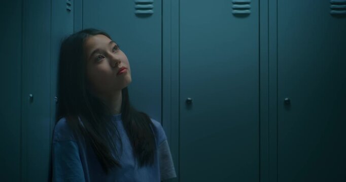 Young Teenage Girl Resting beside School Lockers, Gazing into Distance as Processes Emotions after Busy School Day. Concept of Mental Health, Resilience, Education and Adolescence in Modern School.