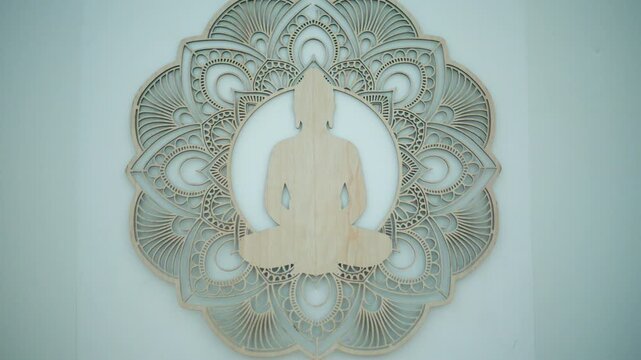 Buddha silhouette wood cutout sitting in meditation pose, centered on a layered mandala wall decoration