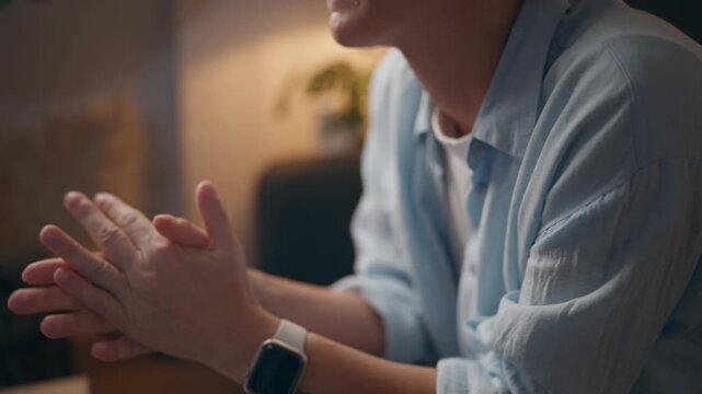Exhausted woman sitting on sofa and rubbing hands together, showing stress, emotional fatigue, burnout and overwhelming pressure after a difficult day.