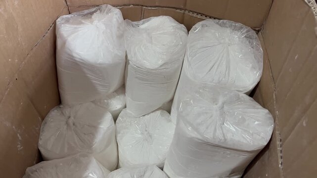 White flour packed in clear plastic bags inside cardboard box