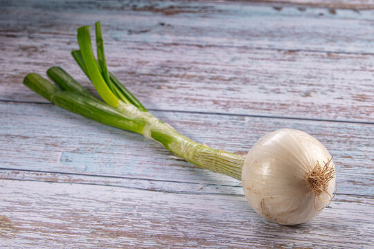 Fresh spring onion on rustic wooden surface