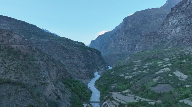 Aerial view of bridge on a fast-flowing mountain river in a rocky gorge near Jispa Lahaul Valley. Shot by a drone flying over Bhaga river in Lahaul region of Himalayas.
