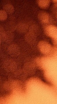 Shadow play on a grunge orange textured wall. Vertical video