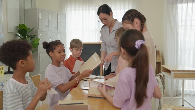 Multicultural school classroom teacher helping diverse children and students during collaborative education learning activity with parent support, teamwork, group study, educational materials