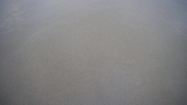 Ocean wave washing away 2026 written on sand beach, new year concept