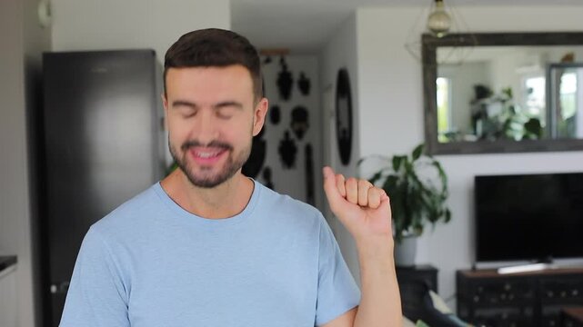 Man smiling and repeatedly opening and closing his fist at camera