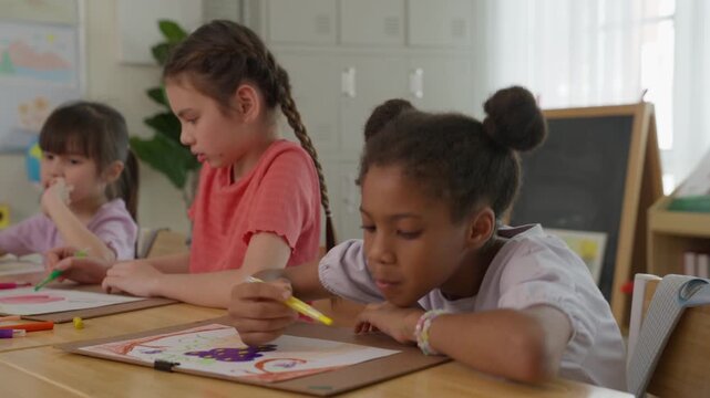 Children Drawing Creative Classroom Art Activity with Diverse Girls Using Pencil and Crayon, Focused Learning, Coloring Artwork, and Curious Classmates Creating Together