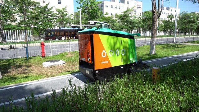Green and orange delivery robot navigating on a city sidewalk  