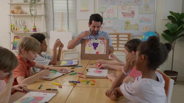 Teacher Showcases Children Artwork During Colorful Classroom Art Activity with Diverse Students Creating Drawings, Creativity, Collaboration, Curiosity, and Joyful Learning Using Paper, Pencils