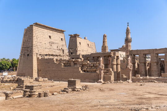 Luxor temple showcasing monumental pylons, grand columns, and statues, with a mosque minaret rising from the complex