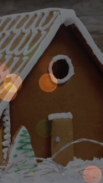 Animation of spots of light over gingerbread house in snow