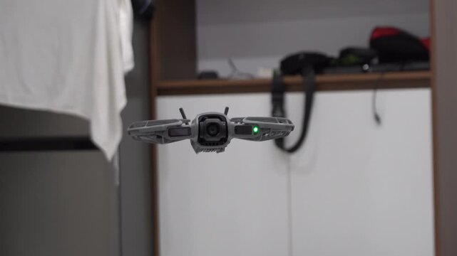 Drone hovering indoors with camera and green light indicator  
