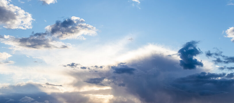 Blue sky with clouds and bright sunbeams breaking through