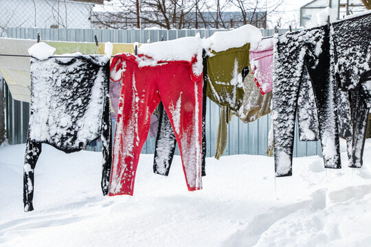 Frozen clothes covered with snow on line in winter yard