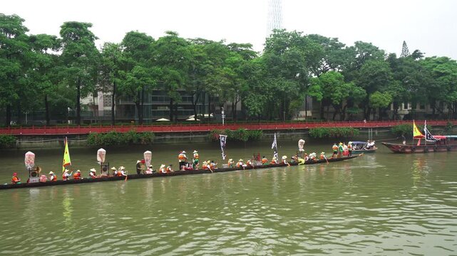 Traditional boat race with participants paddling on a river  