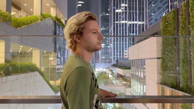 Young Man Using Smartphone Against Skyscrapers &ndash; Talking, Scrolling or Recording Video