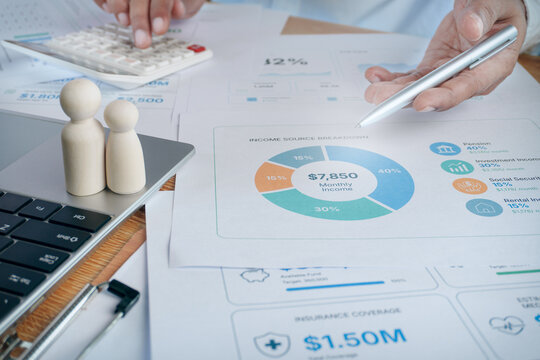 Business professional pointing at financial report document, income source breakdown pie chart, calculator, wooden doll family figures, wealth management concept, budget planning, financial advisory.