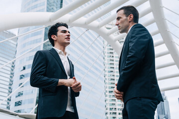 Obraz na płótnie Canvas Two Hispanic Latin Businessmen Talking Serious Discussion Corporate Meeting Modern City Outdoor