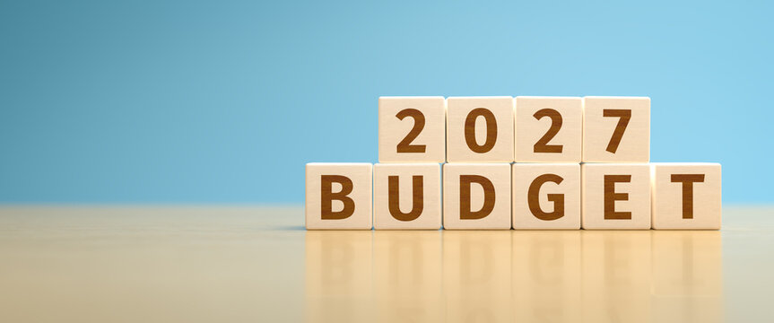 Wooden toy cubes forming the text "2027 BUDGET". Concept for planning the yearly budget for 2027.