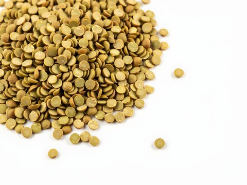 Top-down view of raw green lentils and yellow split peas in white bowl for healthy cooking