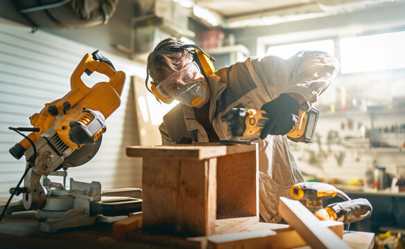 Skilled Carpenter Wearing Safety Gear Working with Wood in Works