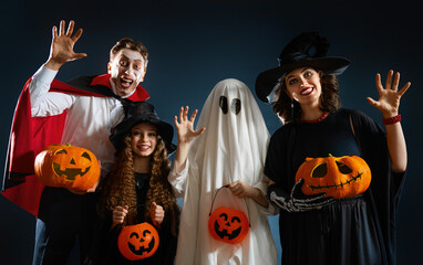 Fototapeta premium Happy Family in Halloween Costumes Celebrating with Pumpkins