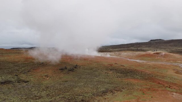 Geothermal steam rises from an active field near Gunnuhver on the Reykjanes Peninsula, Southwest Iceland, across colorful volcanic terrain and mineral deposits, drone orbit and push in.