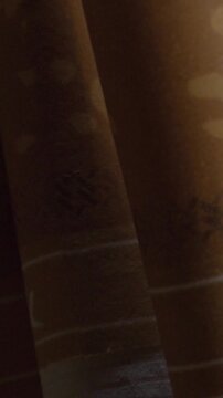 Macro close-up reveals brown cigar paper with fine fibers and subtle mottled texture, highlighting its natural surface and cylindrical form under warm light