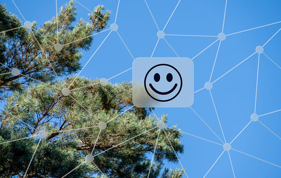 Digitales Umweltkonzept mit einem l&auml;chelnden Smiley vor blauer Himmel und Pinienbaum, vernetzte Technologie und &Ouml;kologie im modernen Zeitalter f&uuml;r Nachhaltigkeit.