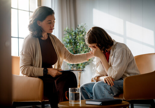 Therapist Comforting Crying Young Woman in Counseling Session