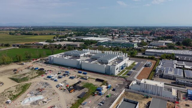 Aerial view of a large data center campus near Milan, featuring extensive digital infrastructure and rooftop solar panels supporting modern cloud computing operations.