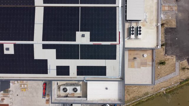 Modern commercial warehouse seen from above, featuring rooftop solar panels and technical cooling infrastructure in an Italian industrial area, relevant to logistics, energy and business themes.