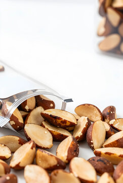 Healthy eating and superfood snack, brazil nuts spilling from a bag, rich in selenium and antioxidants on white background