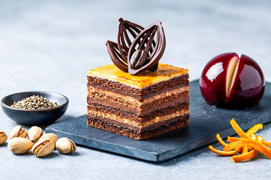 Gourmet layered chocolate opera cake with ornate coffee decoration